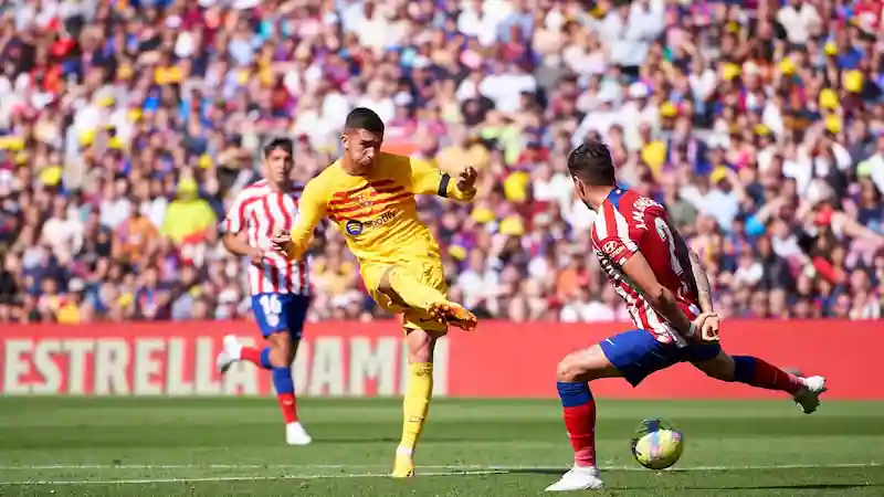 Barcelona narrowly beats Atlético Madrid 1-0 to maintain dominance in the La Liga title race.